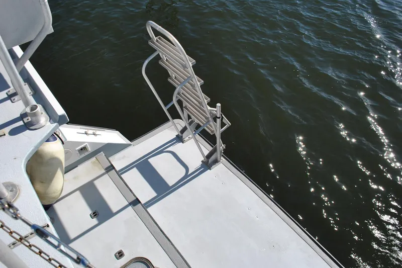 Slide: The Image of Newton 53 dive boat deck with ladder, 2019 model, overlooking water. - 24