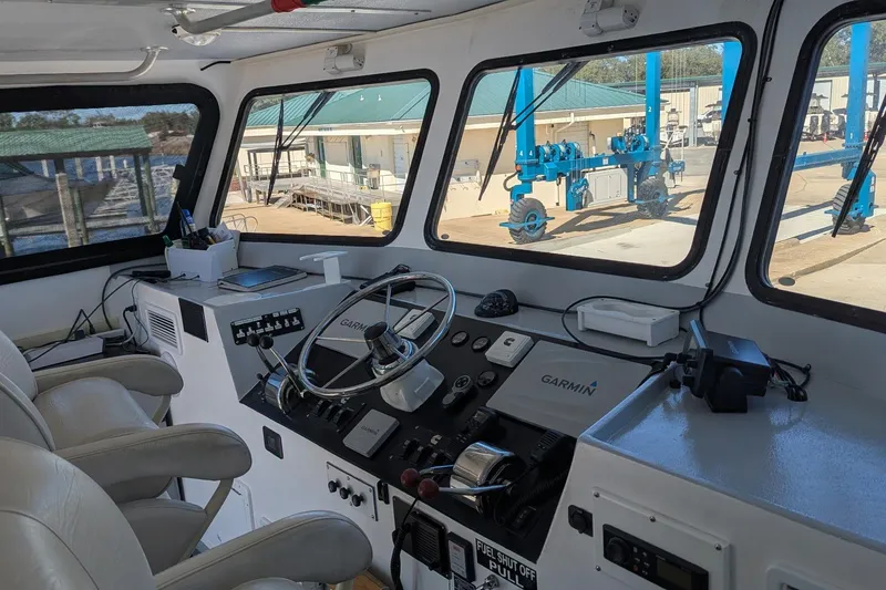 Slide: The Image of Interior of a 2019 Newton 53 dive boat cockpit with steering wheel and navigation equipment. - 27