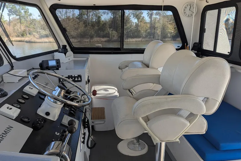 Slide: The Image of Interior of 2019 Newton 53 dive boat with steering wheel and white seating. - 28