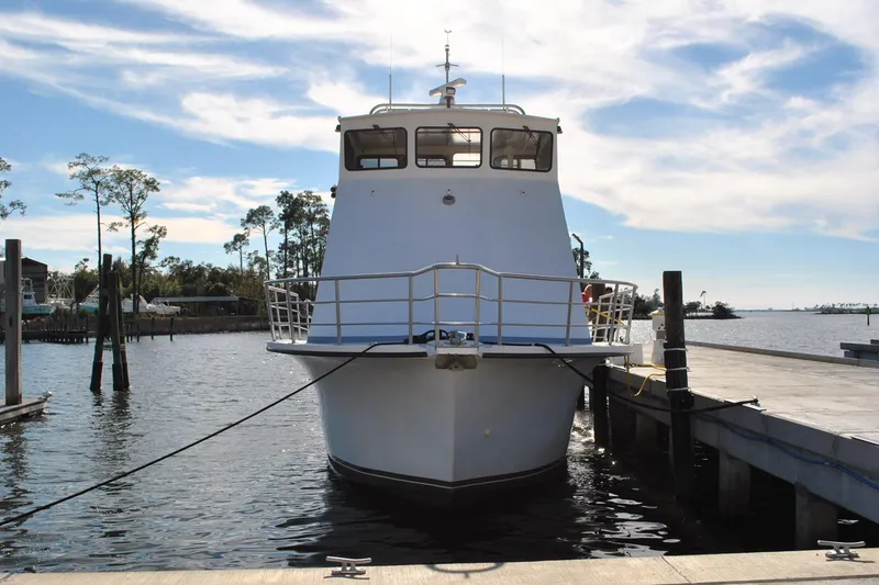 Slide: The Image of 2019 Newton 53 dive boat docked at a marina under a partly cloudy sky. - 3