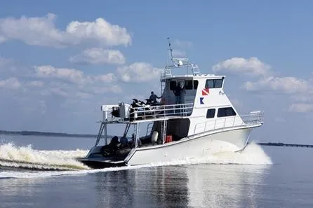 Slide: The Image of 2019 Newton 53 dive boat cruising on open water under a clear sky. - 30