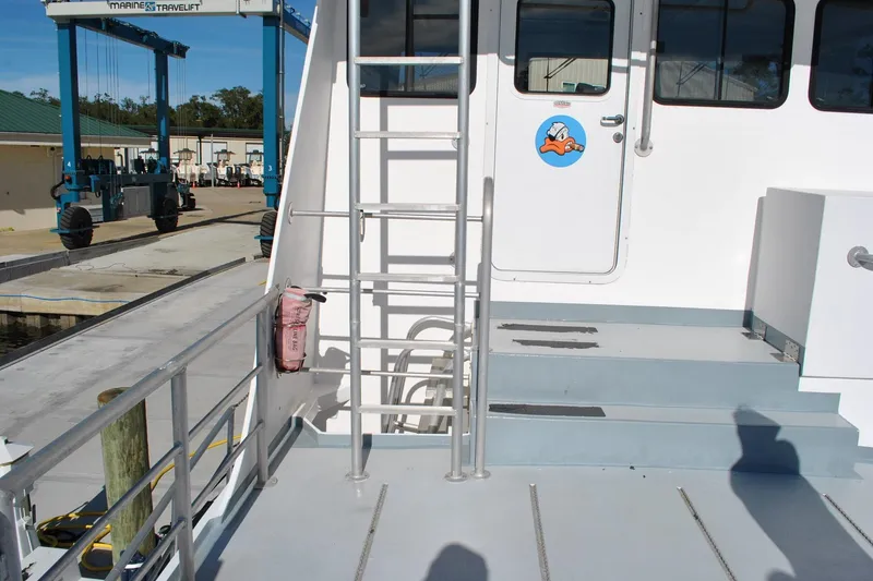 Slide: The Image of Newton 53 dive boat, 2019 model, docked with visible ladder and deck area. - 4