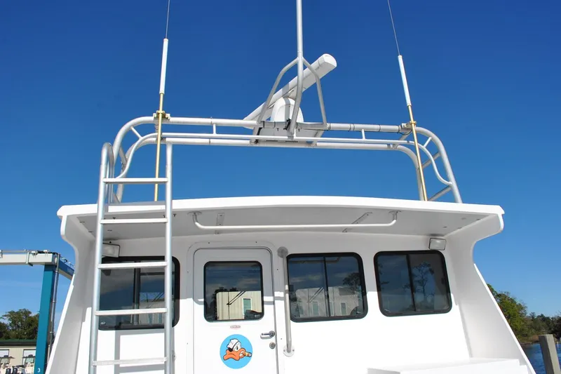 Slide: The Image of 2019 Newton 53 dive boat with radar, ladder, and clear blue sky background. - 5