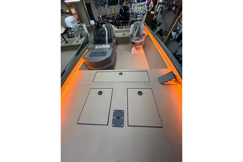 Slide: The Image of 2026 SeaArk Shadow 20T boat interior with storage compartments and orange lighting. - 3