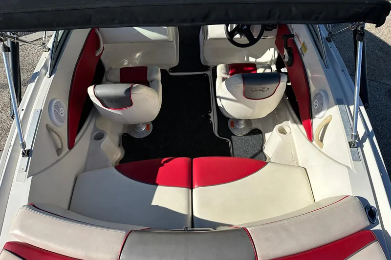 Slide: The Image of 2007 Sea Ray 195 Sport boat interior with red and white seating, under a black canopy. - 2