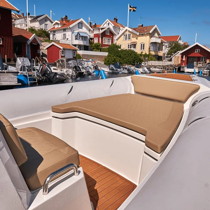 Slide: The Image of 2023 Northstar Orion 7 boat with tan seating, docked near colorful coastal houses. - 4