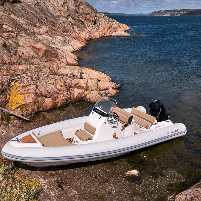 Slide: The Image of 2023 Northstar Orion 7 boat docked by rocky shoreline, clear blue water. - 5