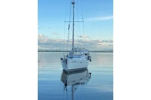 Slide: The Image of 2006 Beneteau Oceanis Clipper 393 sailboat on calm water, reflecting serene sky. - 5
