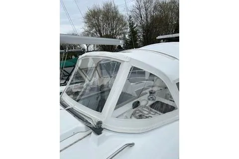 Slide: The Image of 2006 Beneteau Oceanis Clipper 393 sailboat with cockpit enclosure, docked near trees. - 9