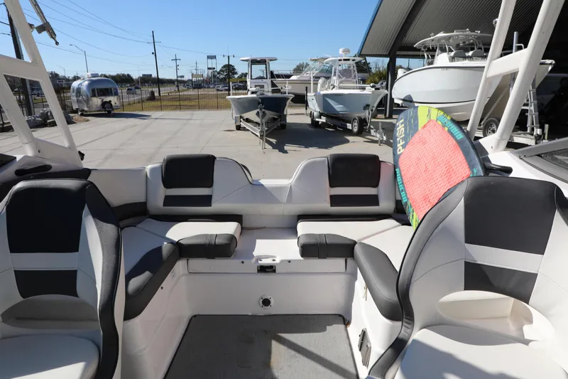 Slide: The Image of 2022 Yamaha Boats AR210 interior with seating and a colorful wakeboard. - 12