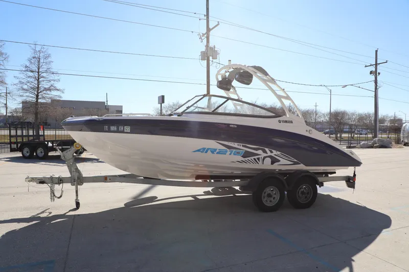 Slide: The Image of 2022 Yamaha AR210 boat on trailer, parked outdoors in a sunny setting. - 6