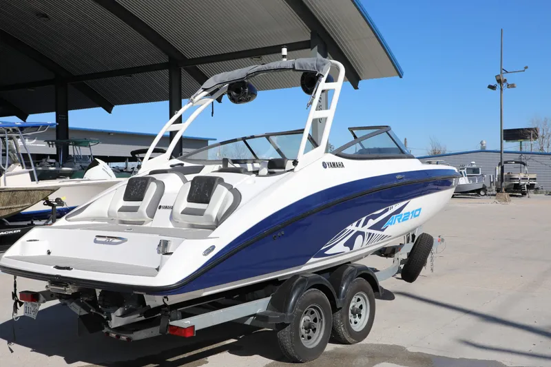 Slide: The Image of 2022 Yamaha AR210 boat on trailer, parked outdoors under a canopy. - 7