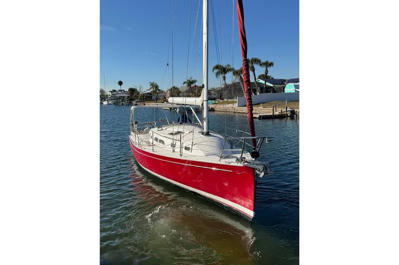 The Image of Red 2006 Shannon Shoalsailer sailboat docked in sunny marina with palm trees. - 0