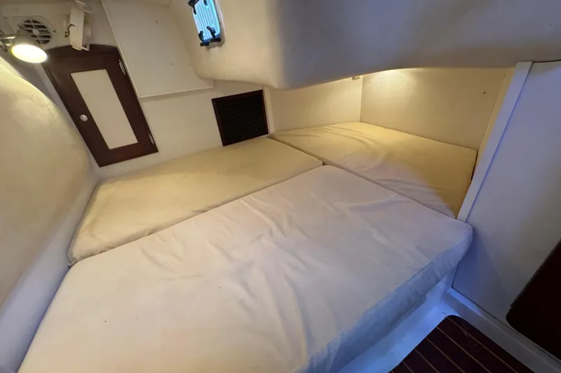 Slide: The Image of Cozy cabin interior of 2006 Shannon Shoalsailer with twin beds and soft lighting. - 17