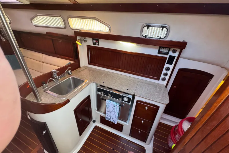 Slide: The Image of 2006 Shannon Shoalsailer yacht interior with kitchen, sink, stove, and wooden cabinetry. - 9