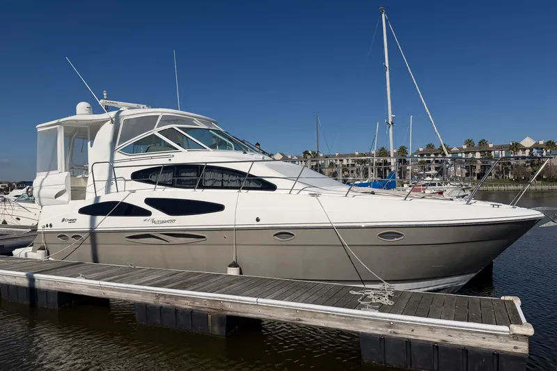 Slide: The Image of 2011 Cruisers Yachts 415 Express Motoryacht docked at marina under clear blue sky. - 2
