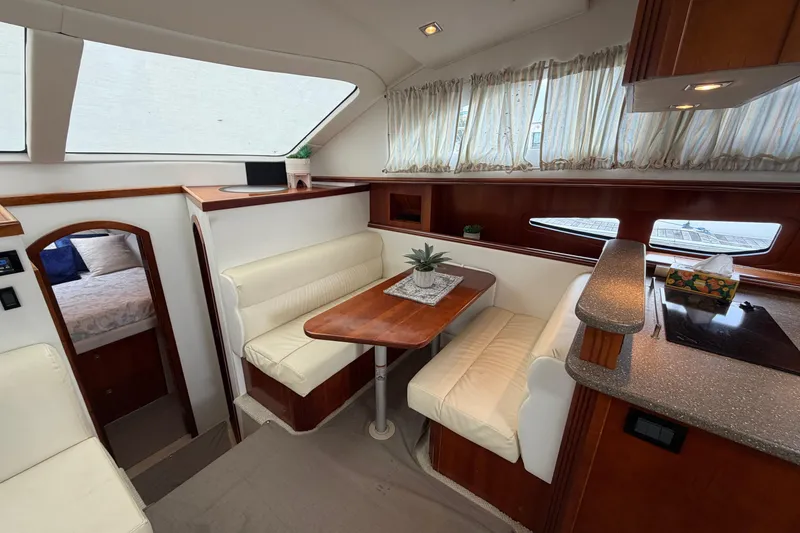 Slide: The Image of 2011 Cruisers Yachts 415 Express Motoryacht interior with dining area and cozy seating. - 29