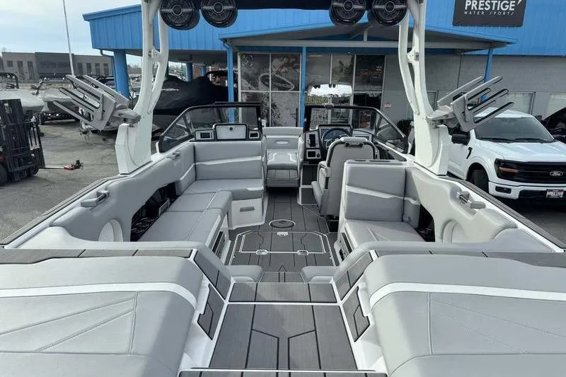 Slide: The Image of 2022 Supra SL boat interior with gray seating and modern design at a dealership. - 12