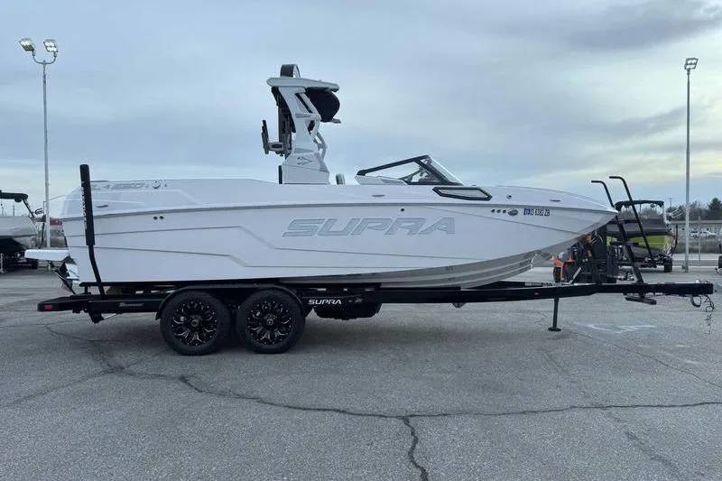 Slide: The Image of 2022 Supra SL boat on trailer in parking lot, side view. - 5