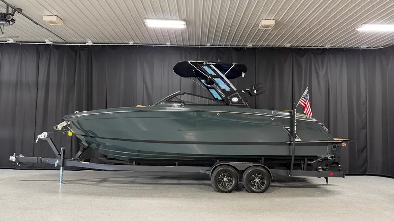 Slide: The Image of The image shows a 2027 Cobalt R8 Surf boat on a trailer in a showroom. - 0
