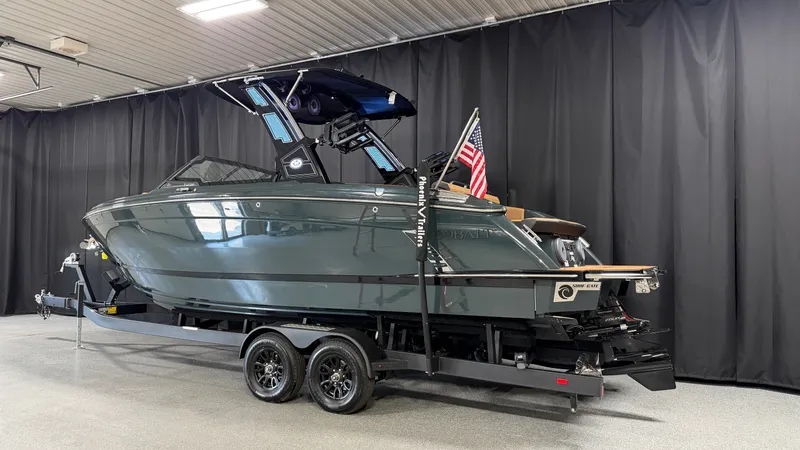 Slide: The Image of The image shows a 2027 Cobalt R8 Surf boat on a trailer in an indoor setting. - 3