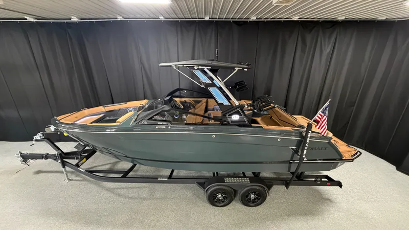 Slide: The Image of The image shows a 2027 Cobalt R8 Surf boat on a trailer in a showroom. - 1