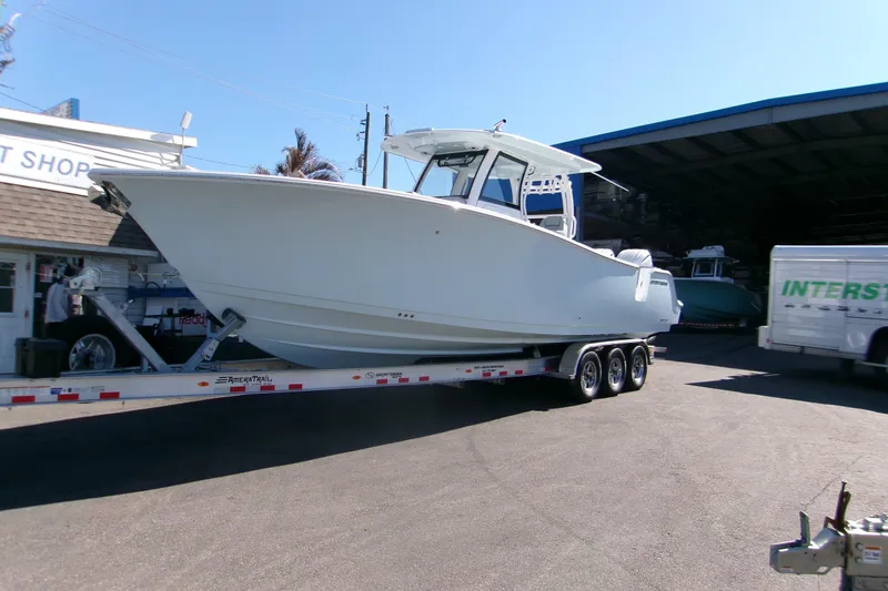 Slide: The Image of 2026 Sportsman Heritage 321 Center Console boat on trailer at marina. - 0