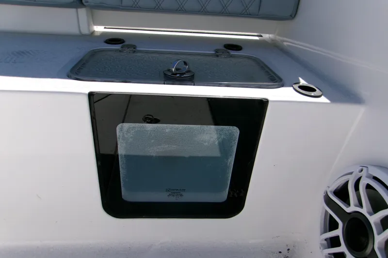 Slide: The Image of 2026 Sportsman Heritage 321 Center Console boat interior with storage compartment and speaker. - 5