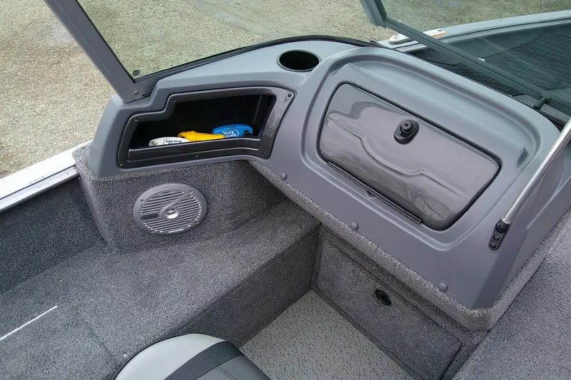 Slide: The Image of 2016 Lund 1775 Impact Sport boat interior with storage compartment and speaker. - 10
