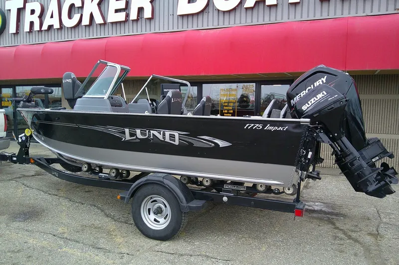 Slide: The Image of 2016 Lund 1775 Impact Sport boat on trailer outside Tracker Boat store. - 2