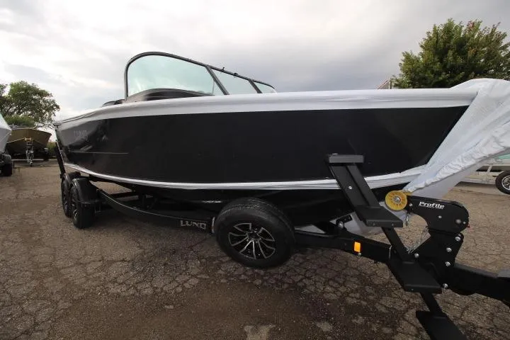 The Image of 2026 Lund 2075 Fisherman boat on trailer, black exterior, parked outdoors. - 0
