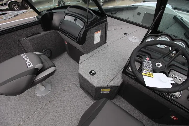 Slide: The Image of 2026 Lund 2075 Fisherman boat interior with steering wheel and seating. - 8