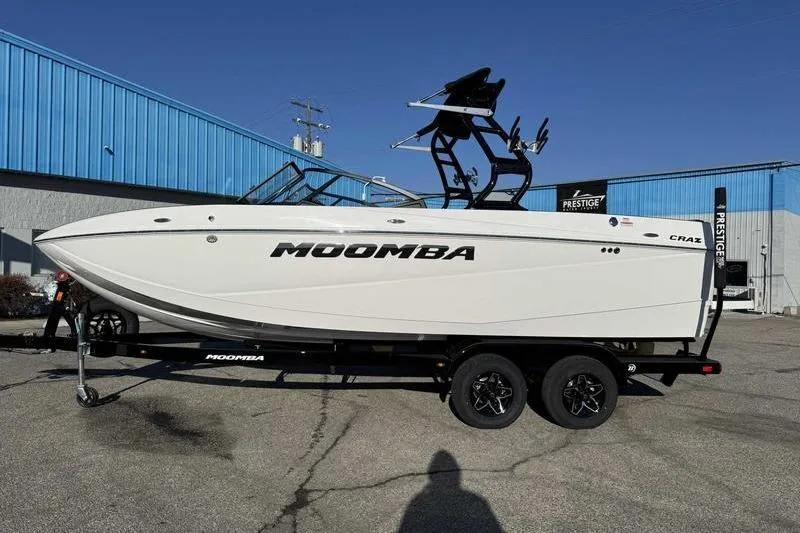 The Image of 2026 Moomba Craz boat on trailer, parked outside a blue building. - 1