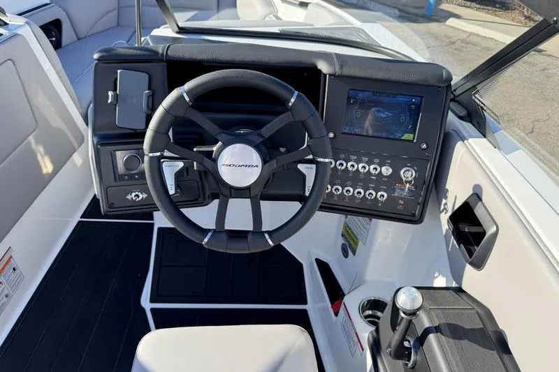 Slide: The Image of 2026 Moomba Craz boat dashboard with steering wheel and control panel. - 9