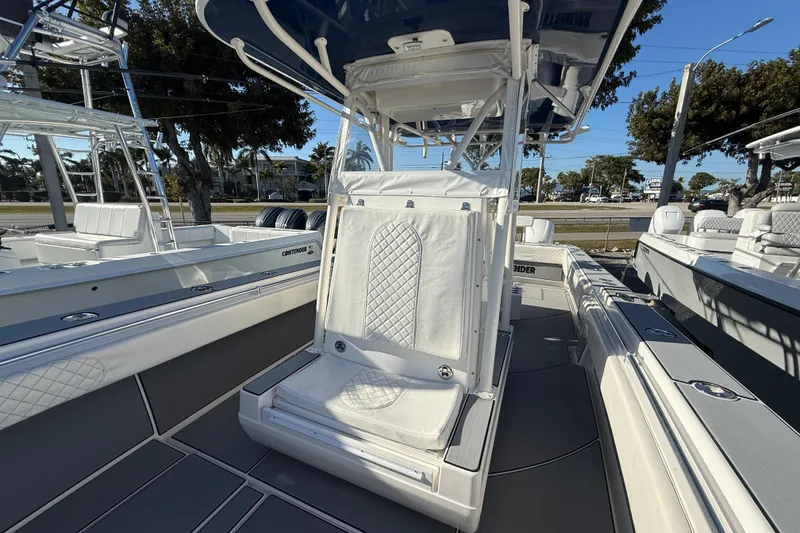 Slide: The Image of 2006 Contender 33 Tournament boat interior with seating and console, docked outdoors. - 11