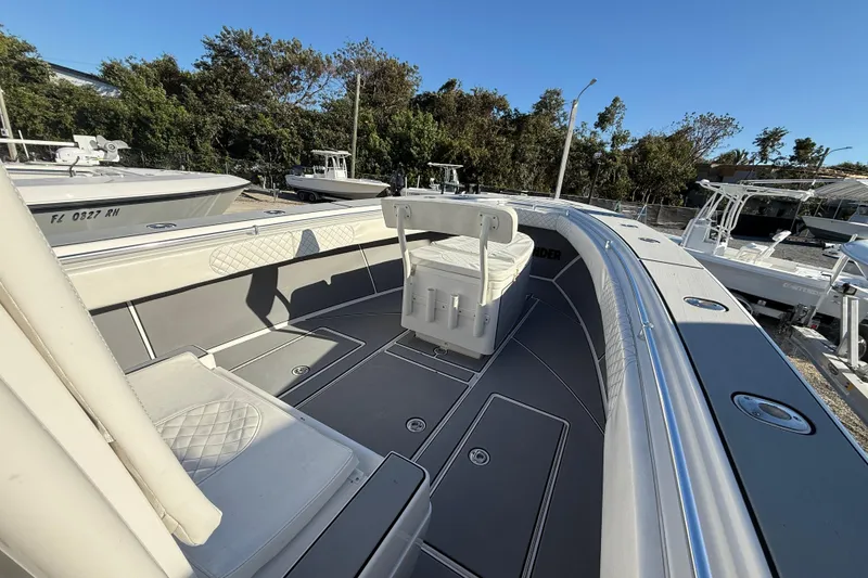 Slide: The Image of 2006 Contender 33 Tournament boat interior with seating and storage, docked outdoors. - 13