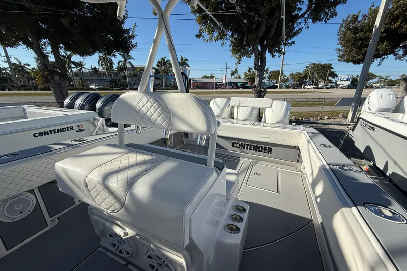 Slide: The Image of 2006 Contender 33 Tournament boat interior with white seating and deck, parked outdoors. - 15