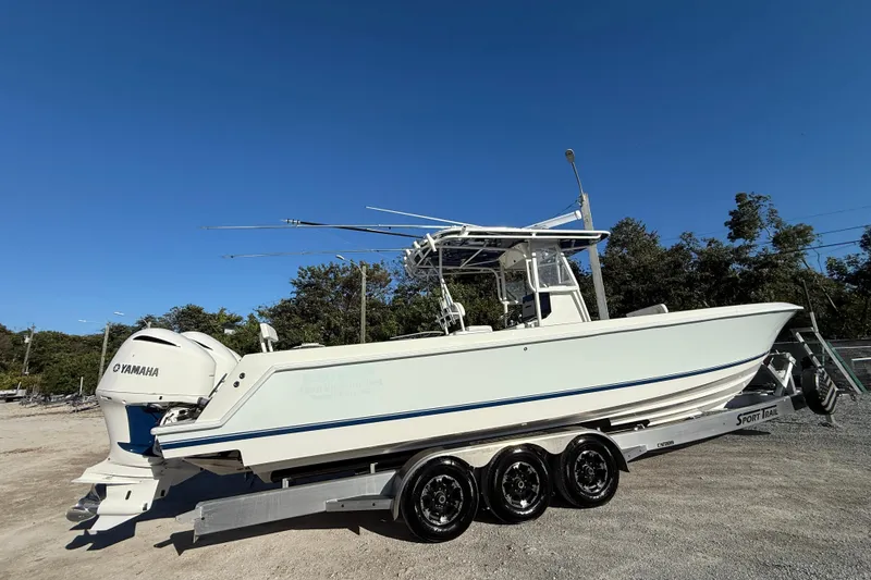 Slide: The Image of 2006 Contender 33 Tournament boat on trailer with Yamaha engines, clear blue sky background. - 3