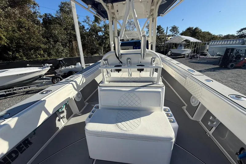 Slide: The Image of 2006 Contender 33 Tournament boat interior with seating and rod holders, docked outdoors. - 7