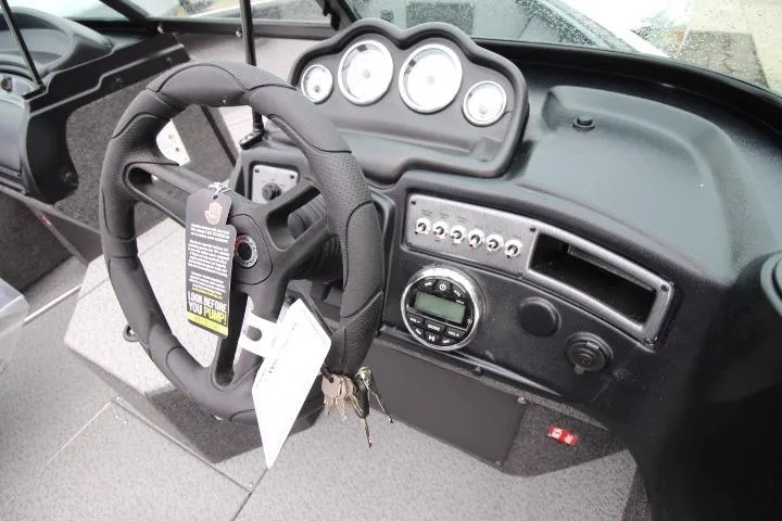 Slide: The Image of 2026 Lund 1875 Fisherman boat dashboard with steering wheel and control panel. - 11