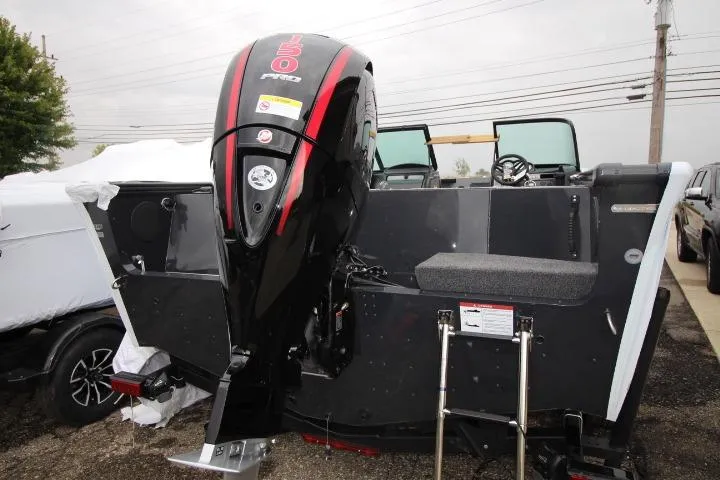 Slide: The Image of 2026 Lund 1875 Fisherman boat with powerful outboard motor, parked outdoors. - 2