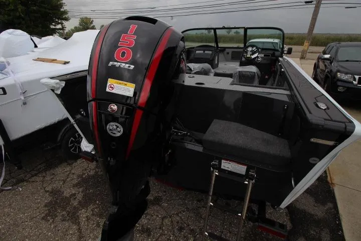 Slide: The Image of 2026 Lund 1875 Fisherman boat with 150 Pro outboard motor, parked outdoors. - 3