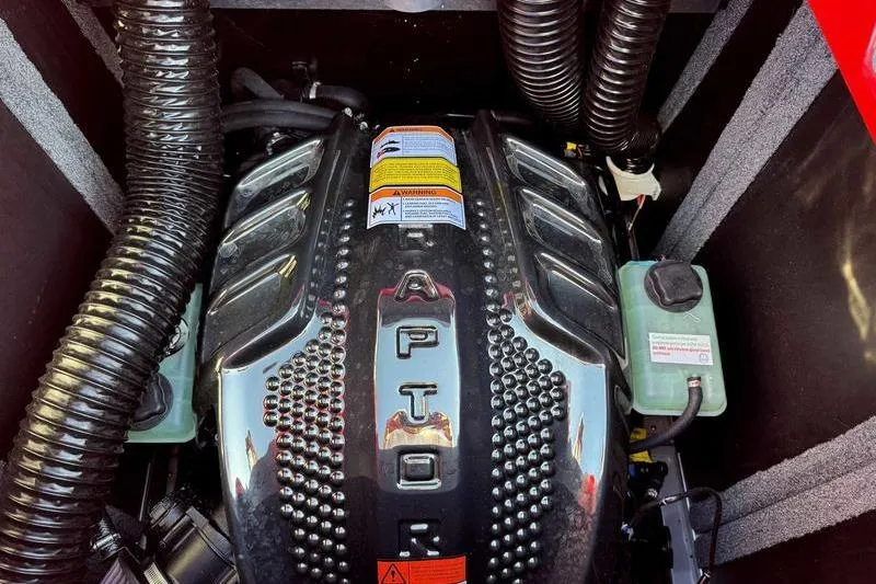 Slide: The Image of 2025 Supra SE engine compartment with Raptor branding and warning labels. - 16