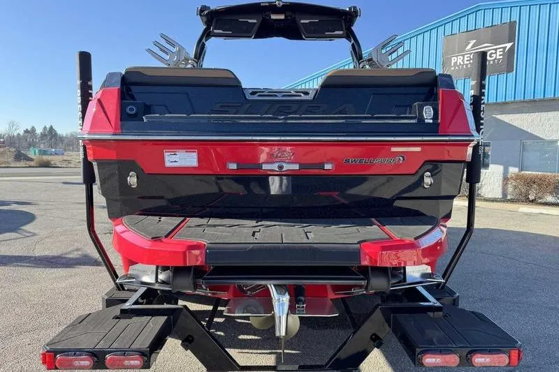 Slide: The Image of 2025 Supra SE boat rear view, featuring red and black design, parked outdoors. - 4