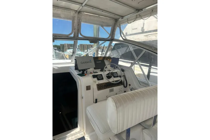 Slide: The Image of 2002 Mainship Pilot 34 helm with Garmin navigation system, featuring a white interior and steering wheel. - 12