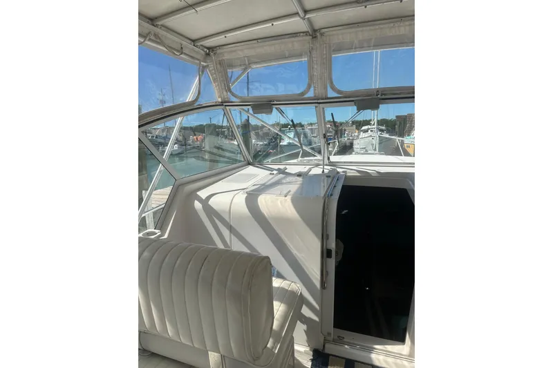 Slide: The Image of 2002 Mainship Pilot 34 boat interior with white seating and marina view. - 13