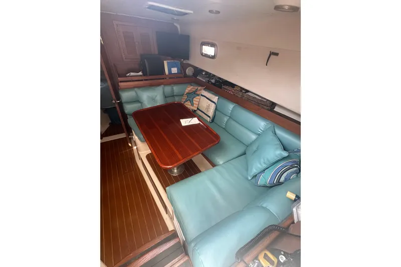 Slide: The Image of Interior of 2002 Mainship Pilot 34 with teal seating and wooden table. - 15