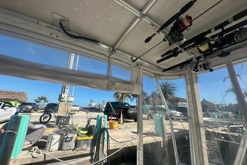 Slide: The Image of Interior view of a 2002 Mainship Pilot 34 boat with fishing rods and dockside scenery. - 28