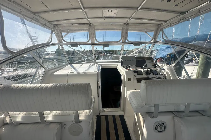 Slide: The Image of 2002 Mainship Pilot 34 boat interior with helm, white seating, and navigation equipment. - 34