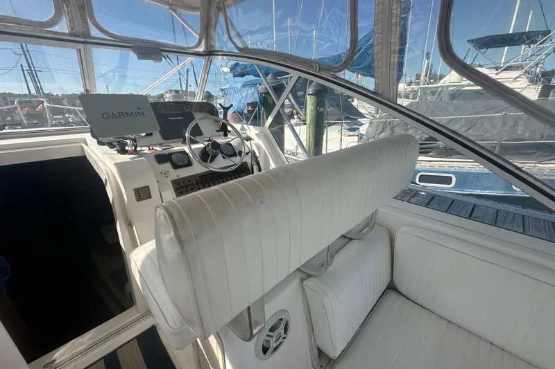 Slide: The Image of 2002 Mainship Pilot 34 cockpit with Garmin navigation, white seating, and marina view. - 39